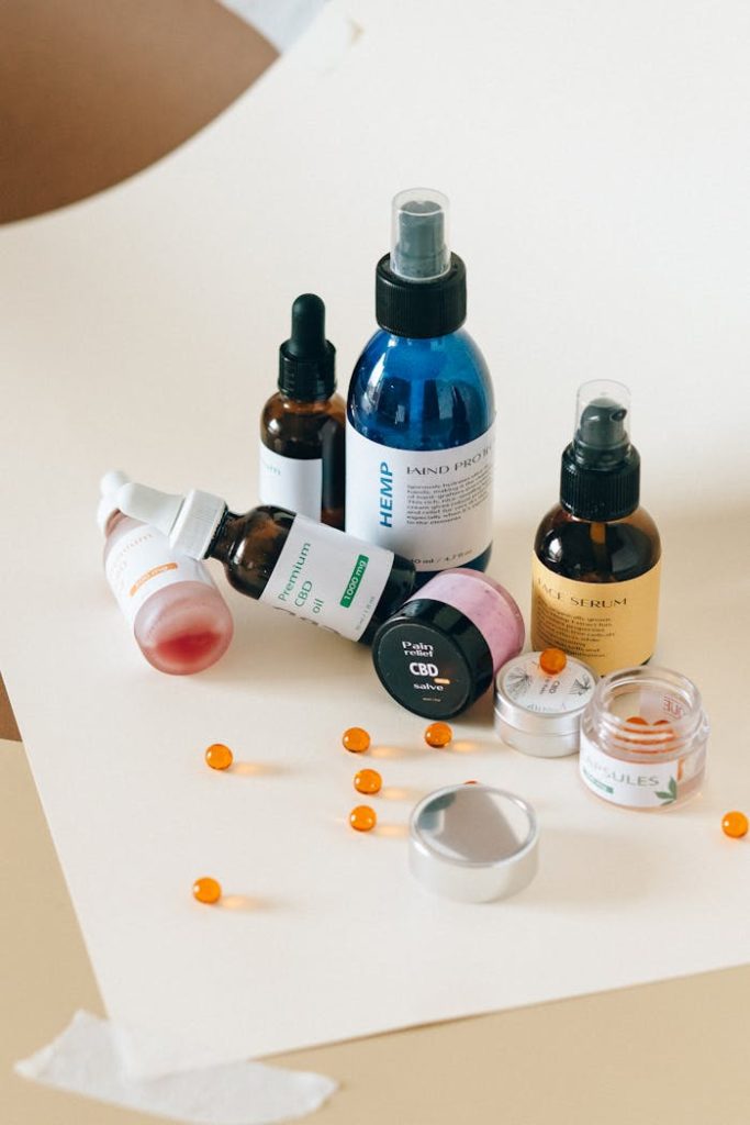 A collection of CBD and hemp products displayed with bottles and capsules on a neutral paper background.